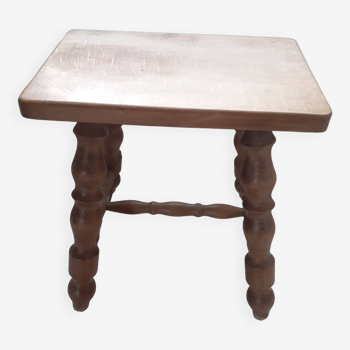 Rectangular wooden stool with 4 turned legs.