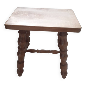 Rectangular wooden stool with 4 turned legs.