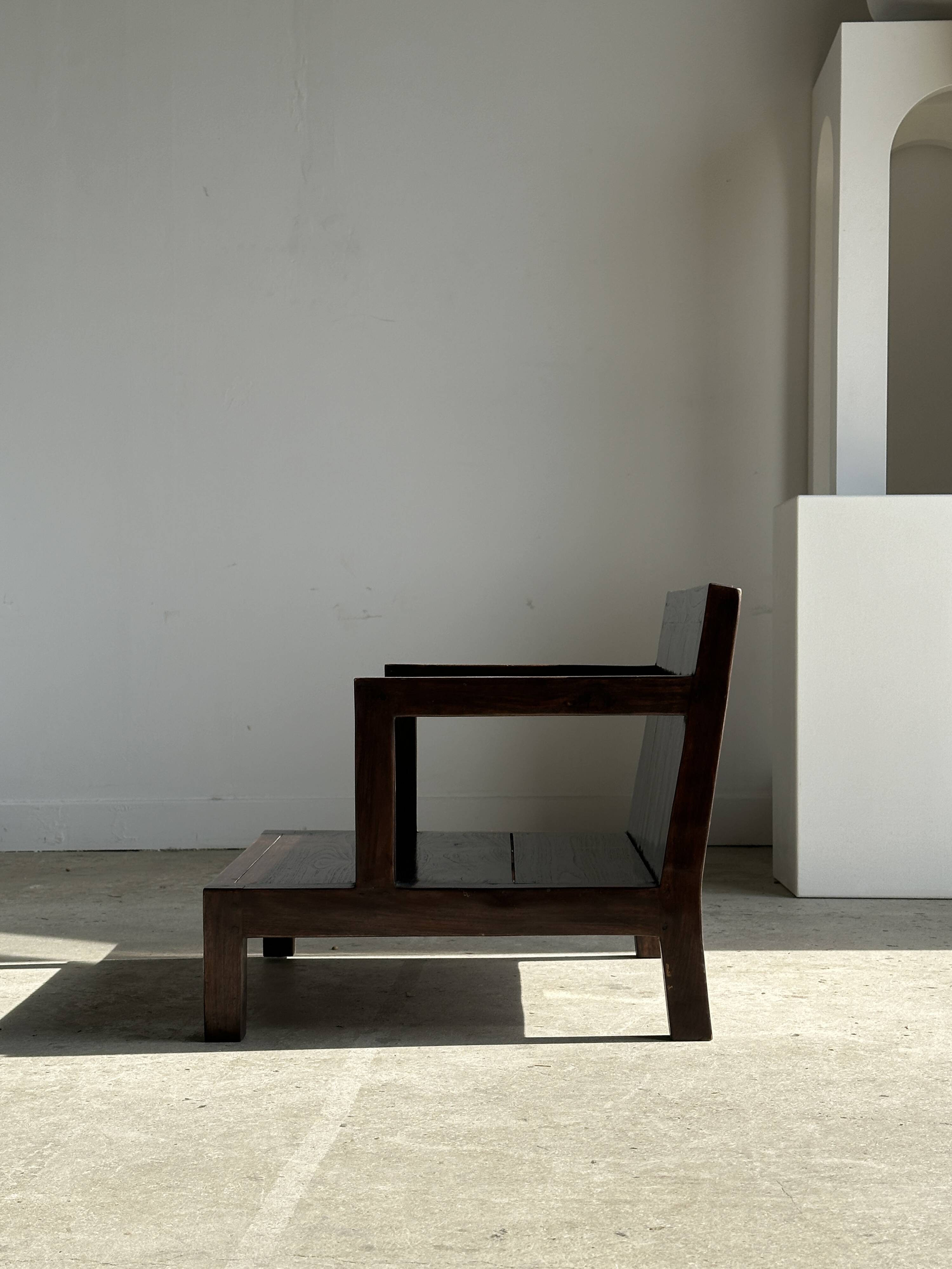 Small low armchair in varnished brown wood