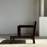 Small low armchair in varnished brown wood