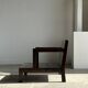 Small low armchair in varnished brown wood