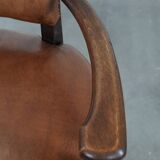 Elegant antique sheepskin leather desk chair with a heavy wooden frame