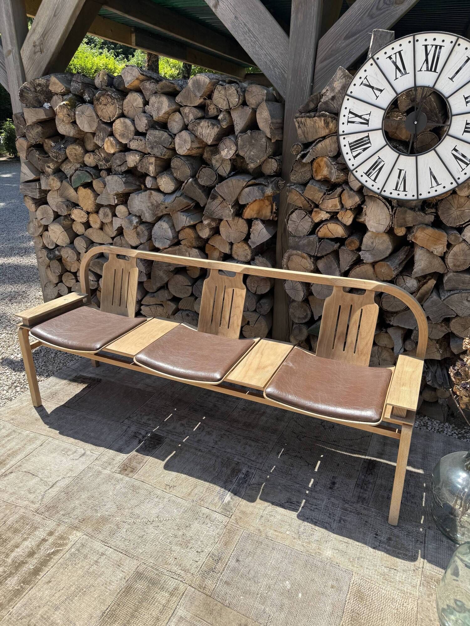 Baumann bench with wooden frame and faux leather seat.