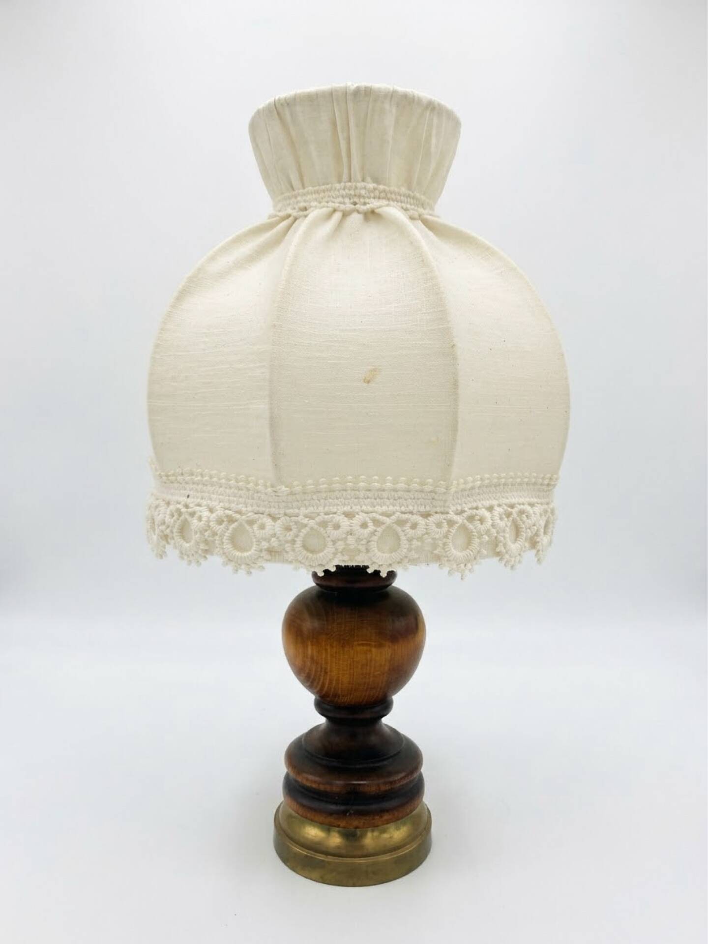 Small vintage wooden turned table lamp with a pleated shade.