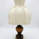 Small vintage wooden turned table lamp with a pleated shade.
