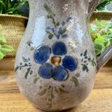 Vintage grey ceramic pitcher with hand-painted blue flower decoration.