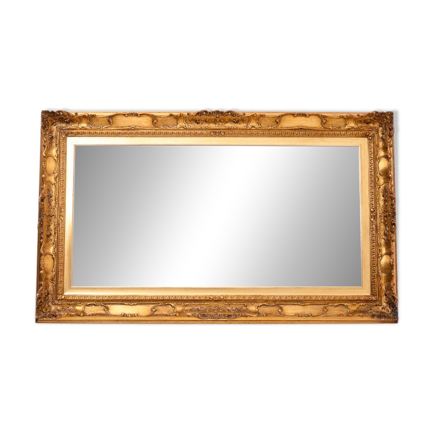 A mirror with a golden, richly carved frame.