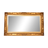 A mirror with a golden, richly carved frame.