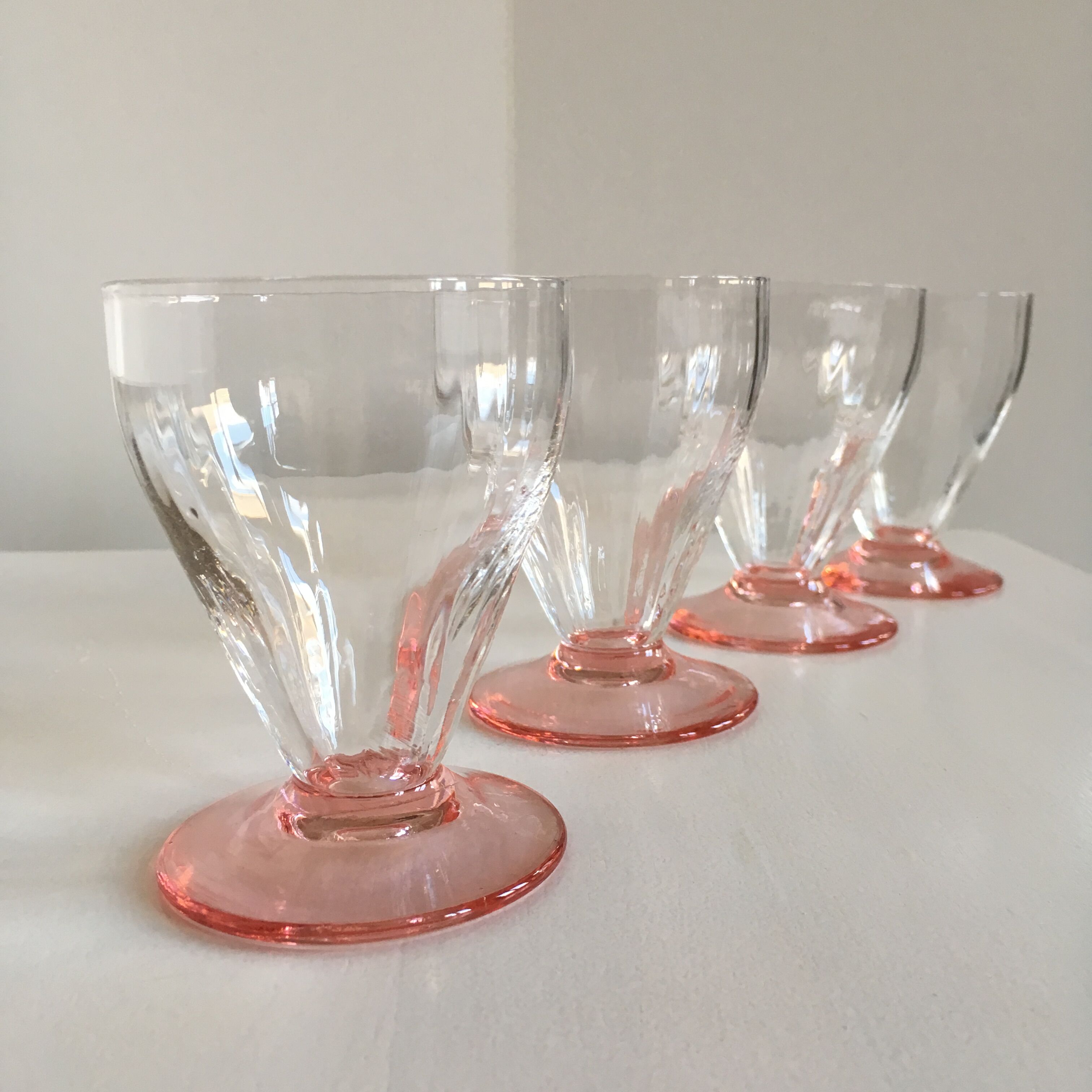 Lot of water in white and pink glass glasses