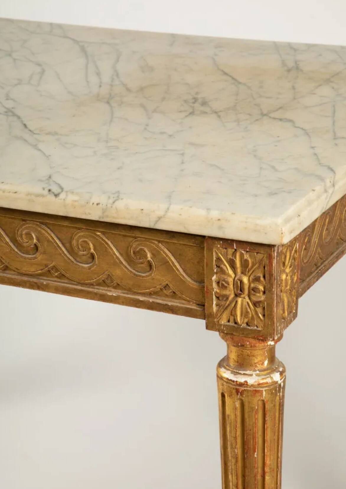 Golden carved wooden centre table with a white marble top.