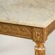 Golden carved wooden centre table with a white marble top.