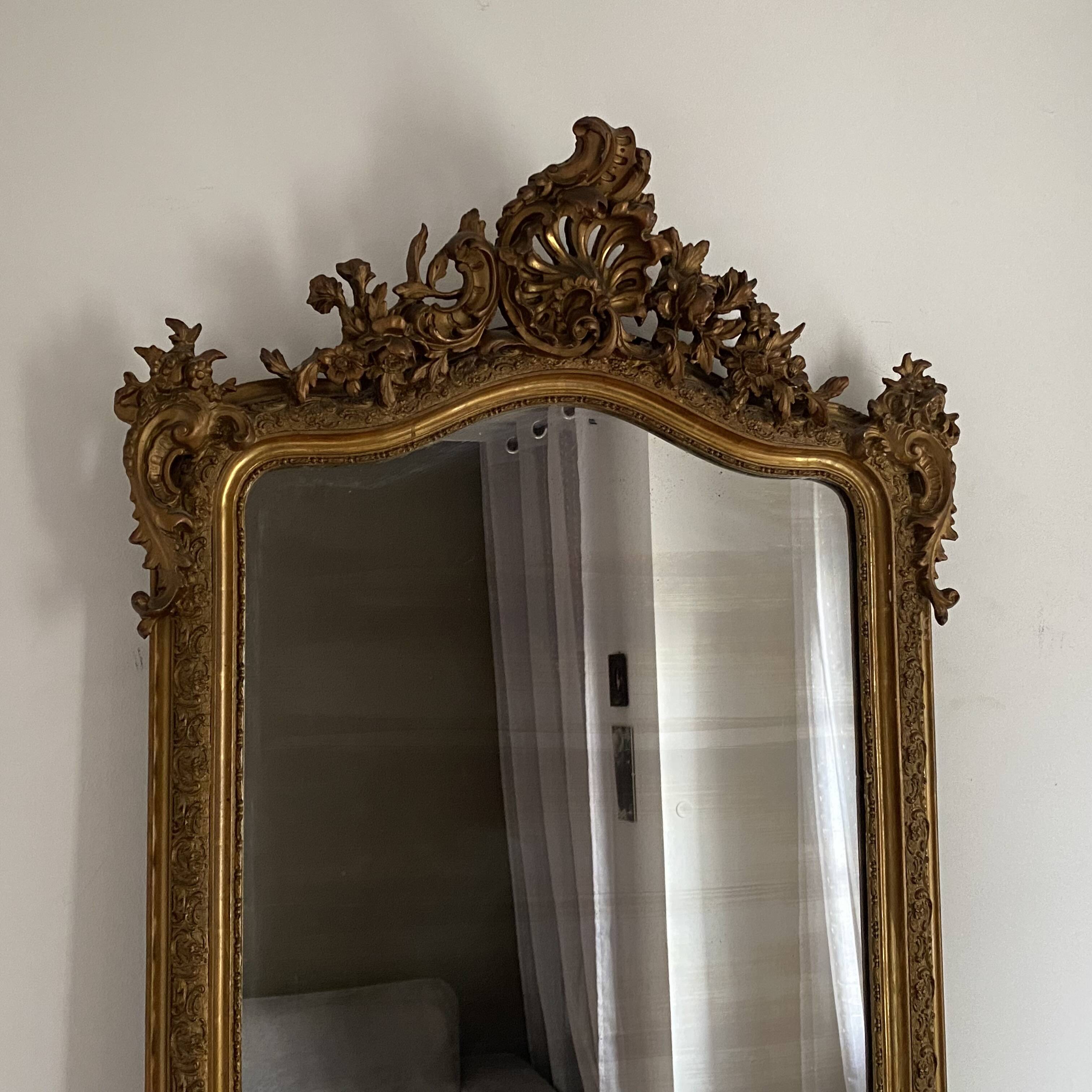 Late 19th century gilded mirror with decorated pediment. 155x88.