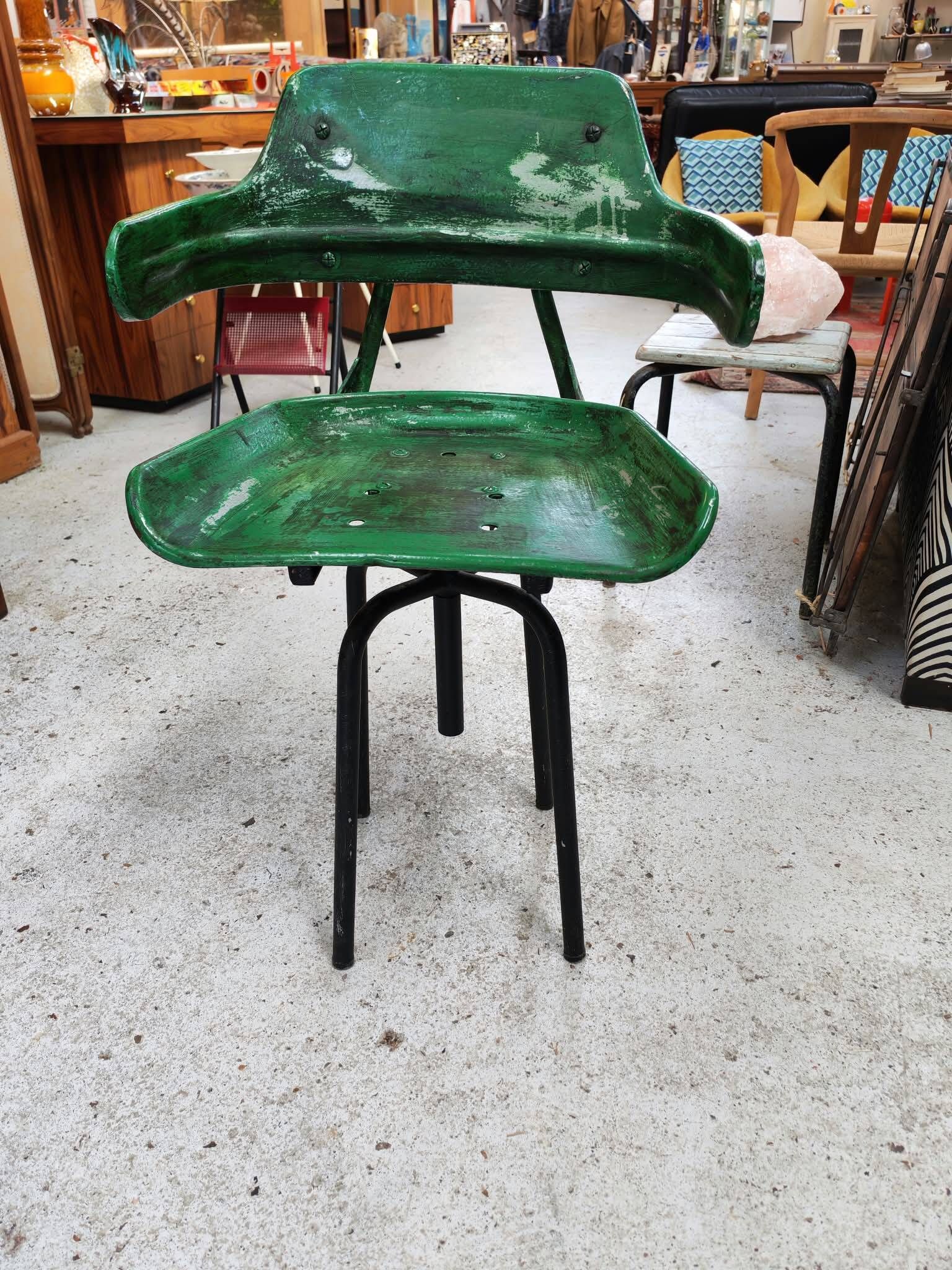 Vintage swivel workshop chair in green pressed sheet metal with a folding backrest.