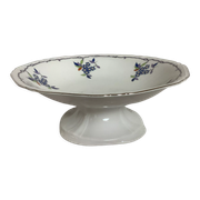 Old shower tray with silver trim and forget-me-not flowers.