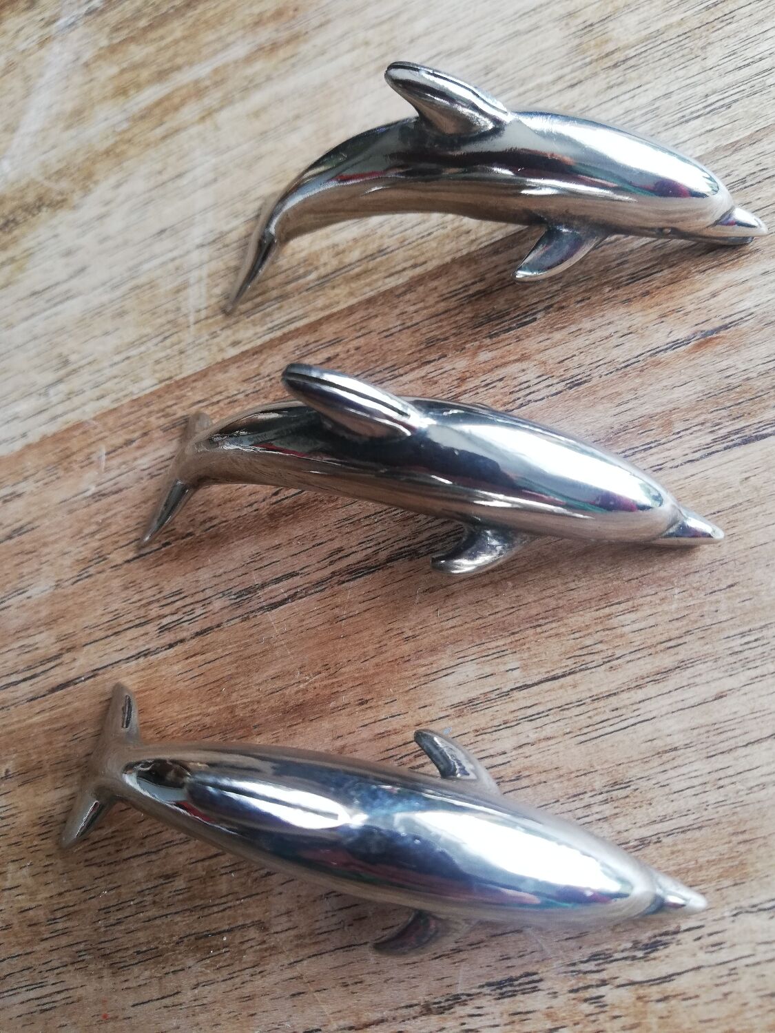Set of three silver metal dolphin place markers