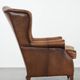Fauteuil à oreilles de style anglais couleur cognac en cuir de vache.