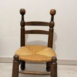 Low fireplace chair in the style of Charles Dudouyt – wood and straw seat.