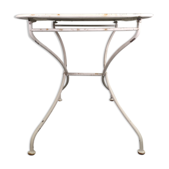 Old folding garden table in white wrought iron