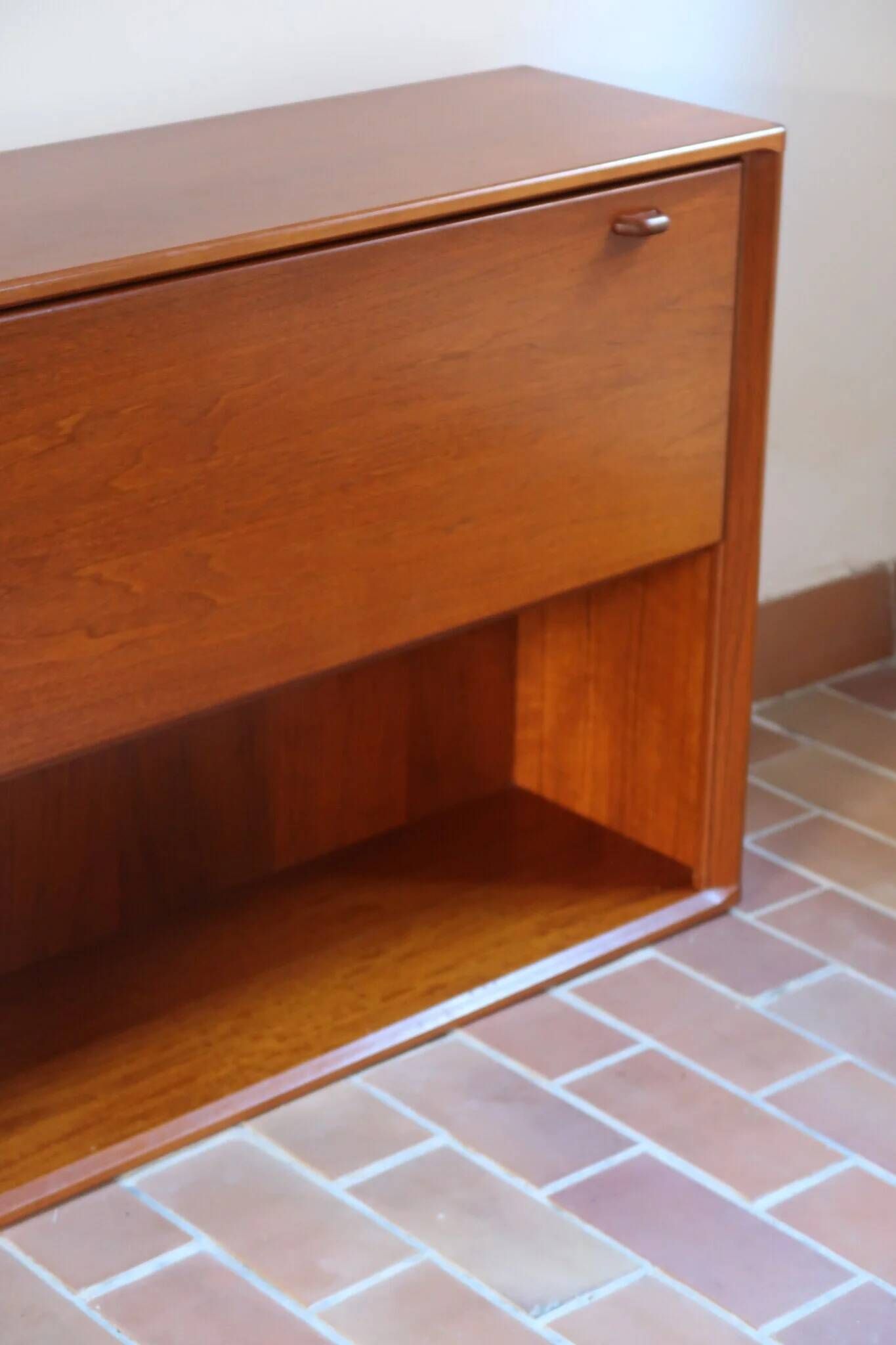 Vintage teak bar cabinet with black glass interior.