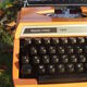 Silver reed orange and black typewriter with bag