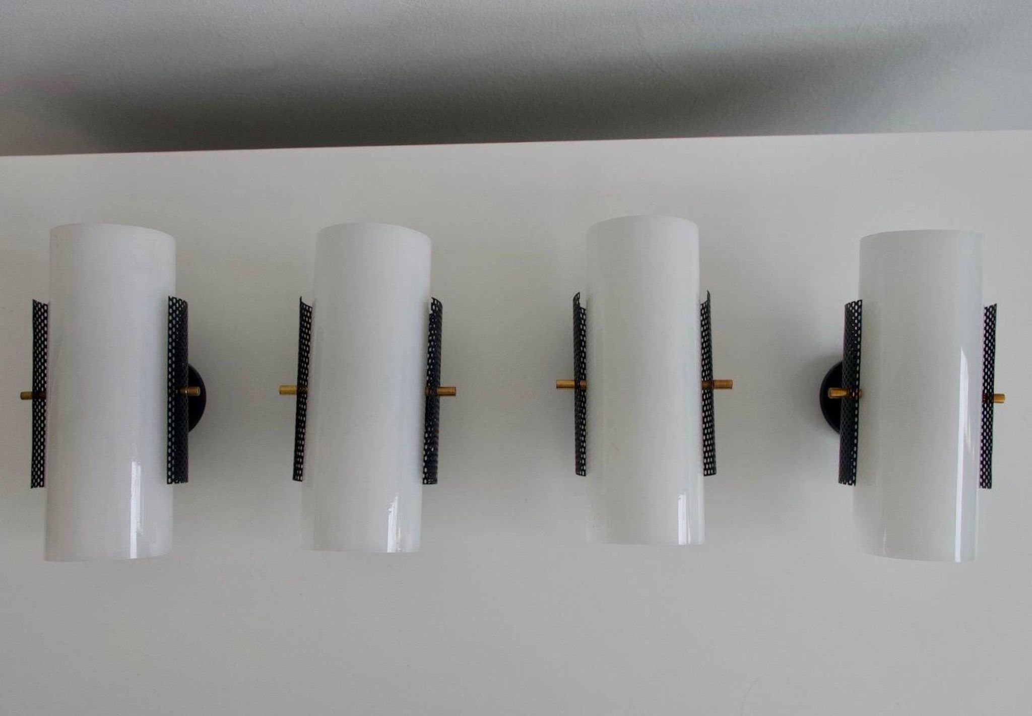 Set of four wall lights in white plexiglass and perforated black metal.