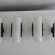 Set of four wall lights in white plexiglass and perforated black metal.