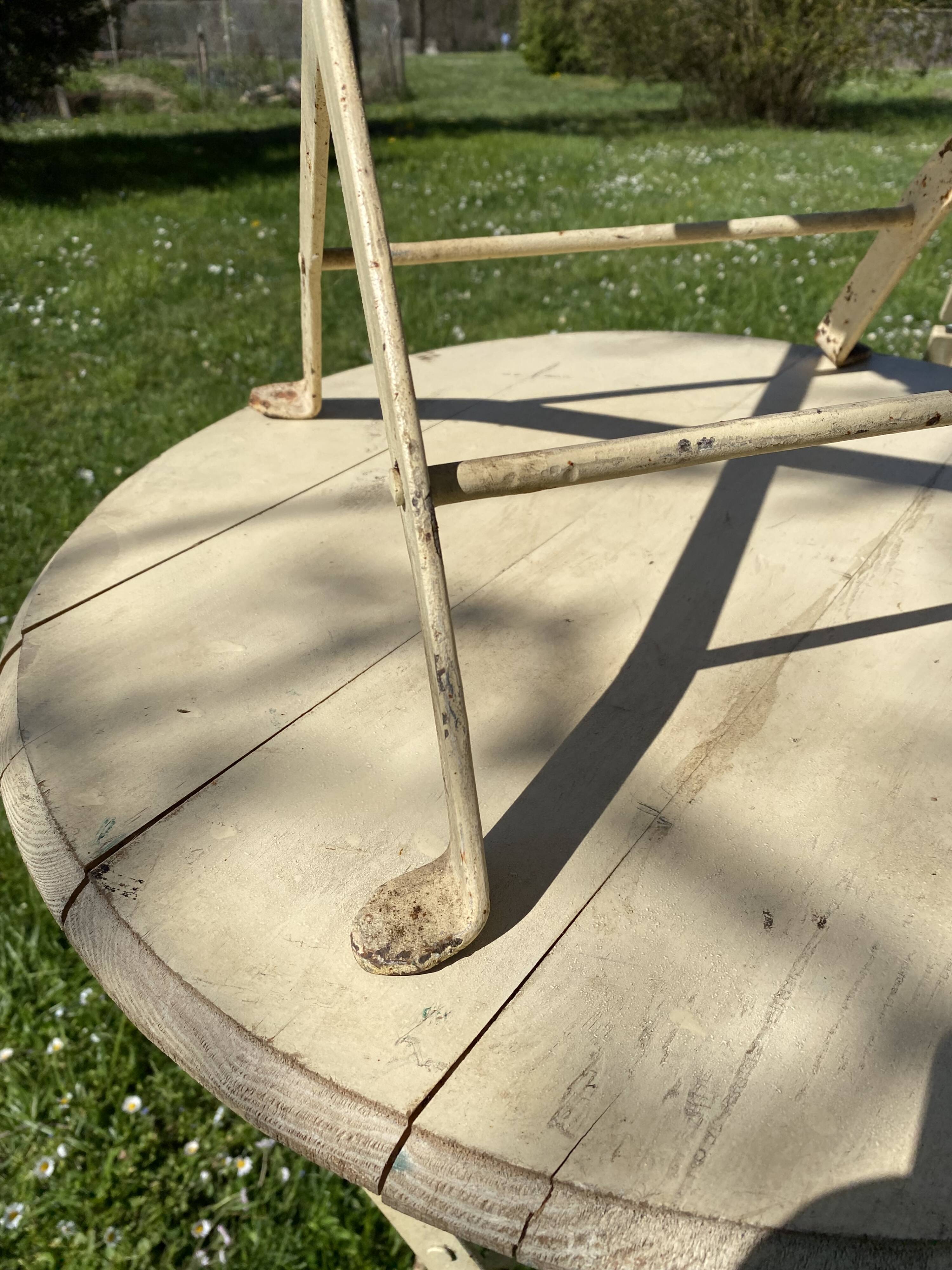Table et 2 chaises de jardin en métal et bois beige marquées "Bistrot Paris"