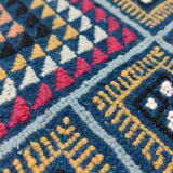 Blue carpet with multicolored patterns woven hands in natural wool