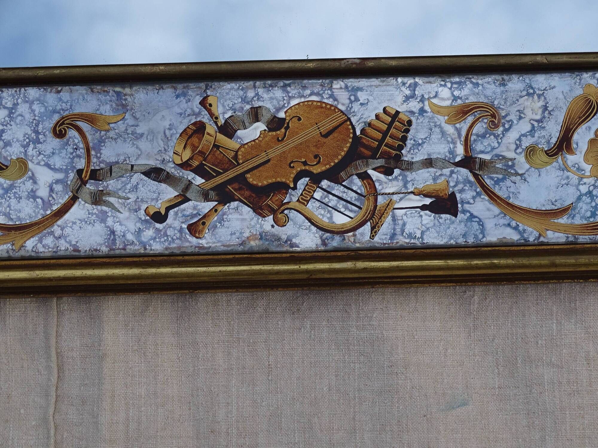 50s Eglomisé glass mirror with musical instrument decor