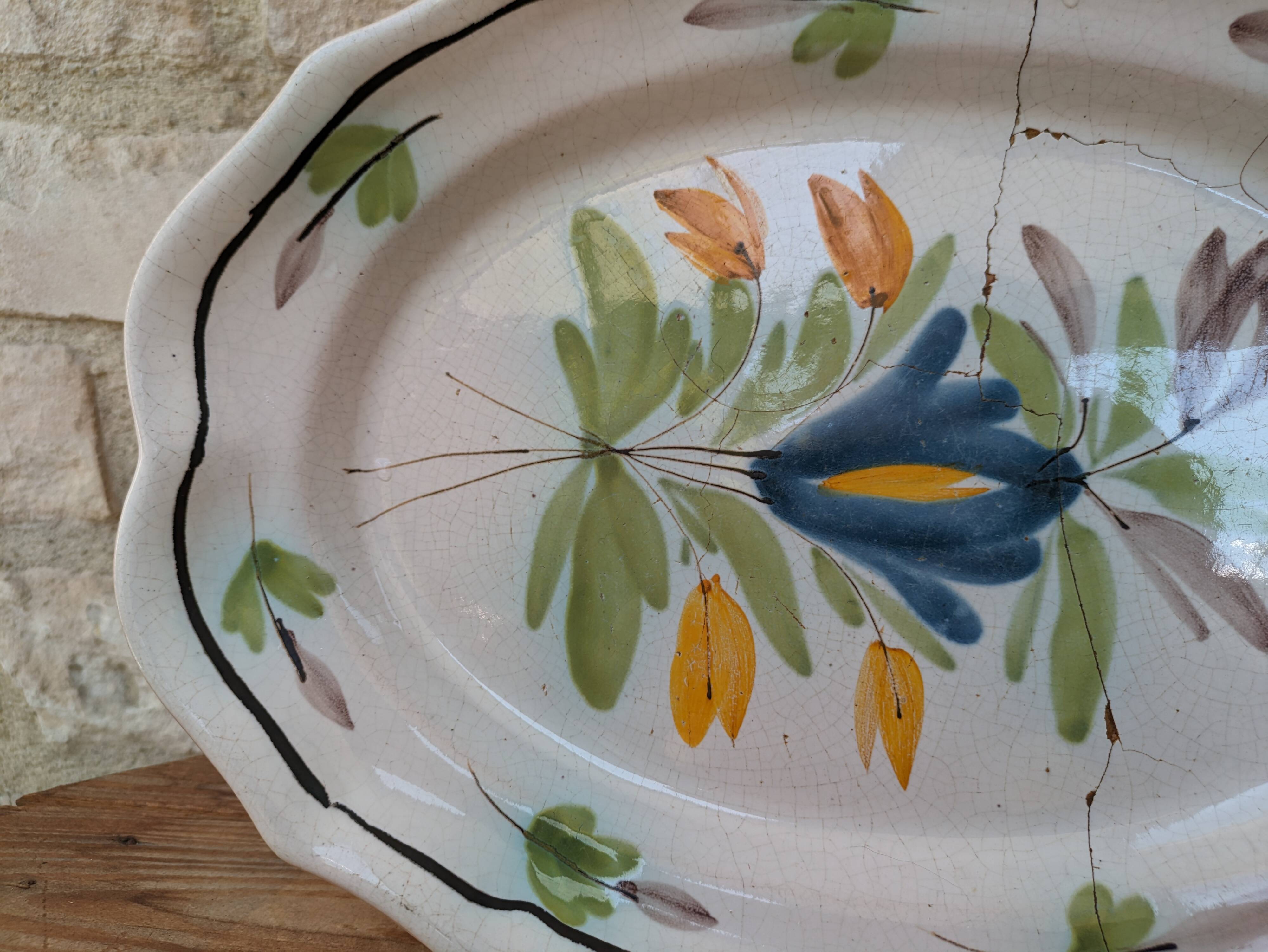 Old oval dish with floral motif called black bottom with staples