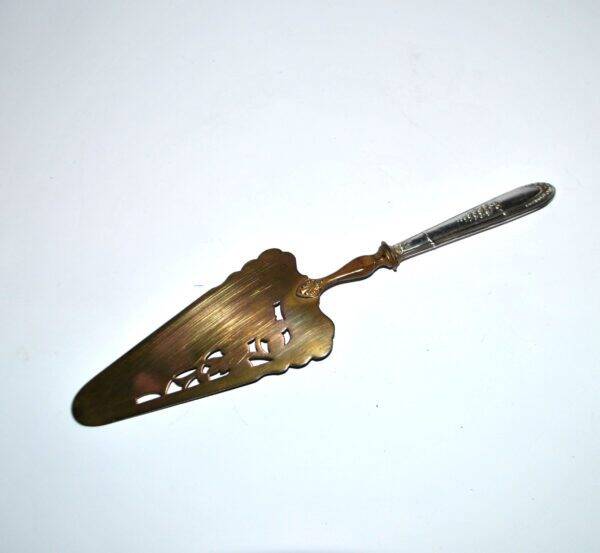 Antique silver-plated pie server with a brass blade decorated with roses.