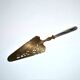Antique silver-plated pie server with a brass blade decorated with roses.