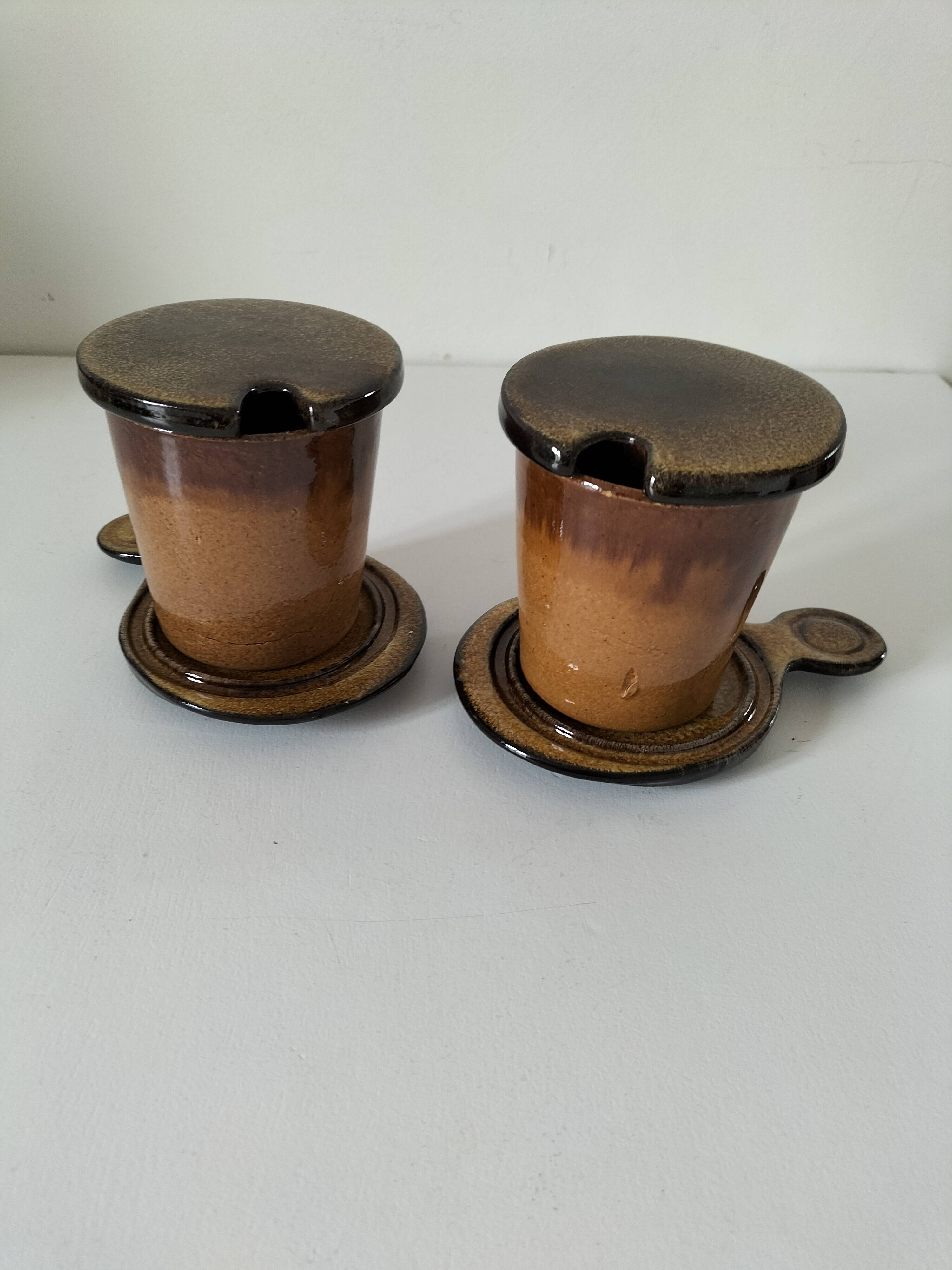 Pair of glazed stoneware cups with saucers and lids