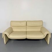 Two-seater designer sofa De Sede DS-2011 in cream leather with adjustable backrest.