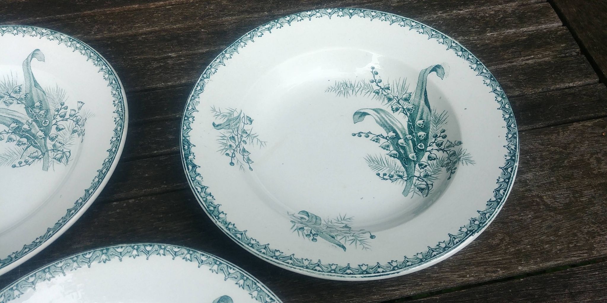 Set of three iron earthenware plates from the St Amandinoise earthenware factory, lily of the valley model.