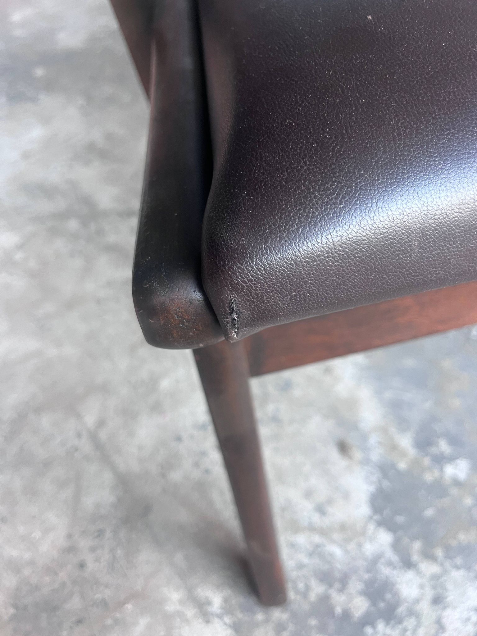 Pair of sculptural mid-century armchairs in dark wood and brown upholstery.
