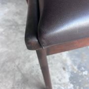 Pair of sculptural mid-century armchairs in dark wood and brown upholstery.