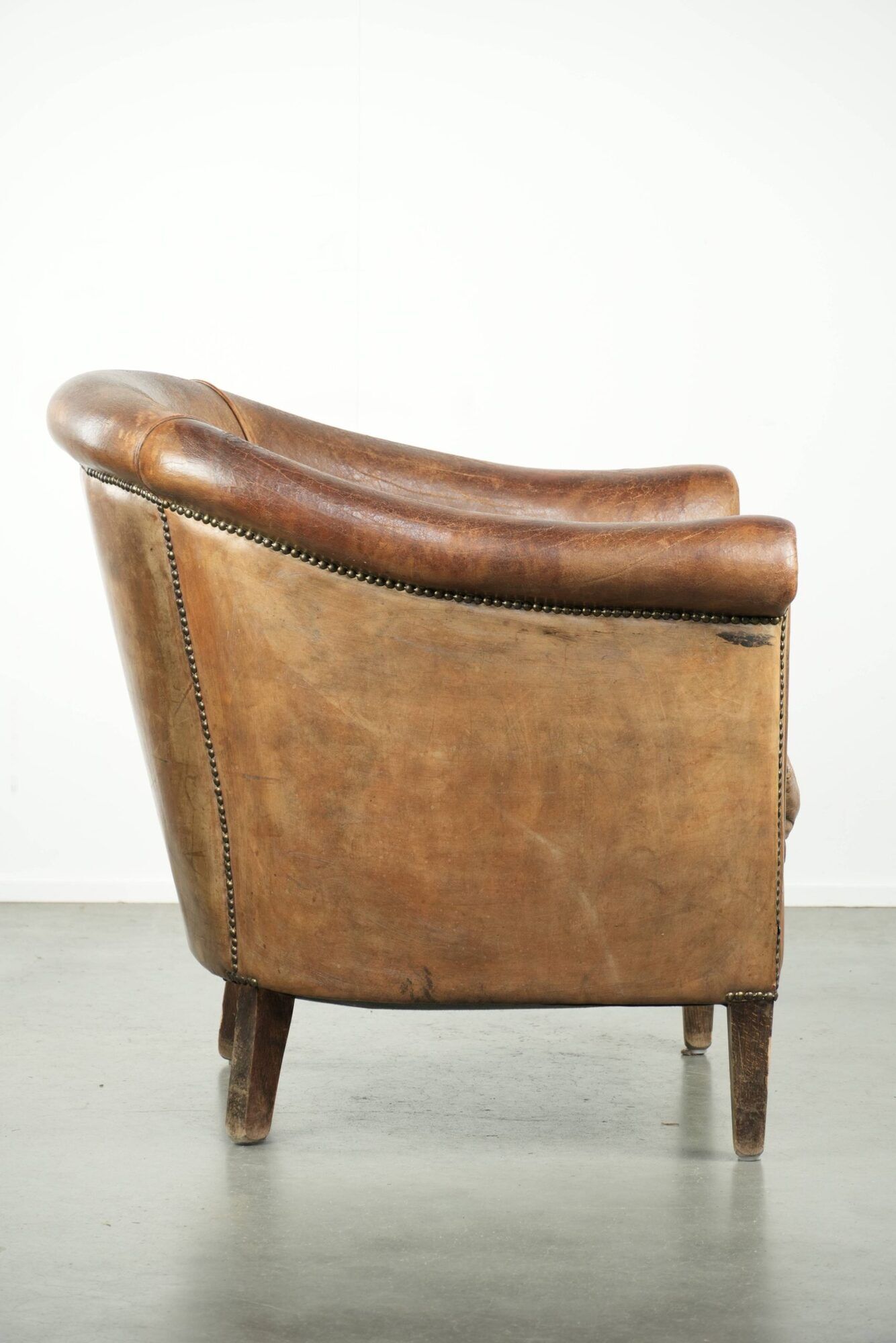 Vintage sheepskin club armchair finished with decorative nails