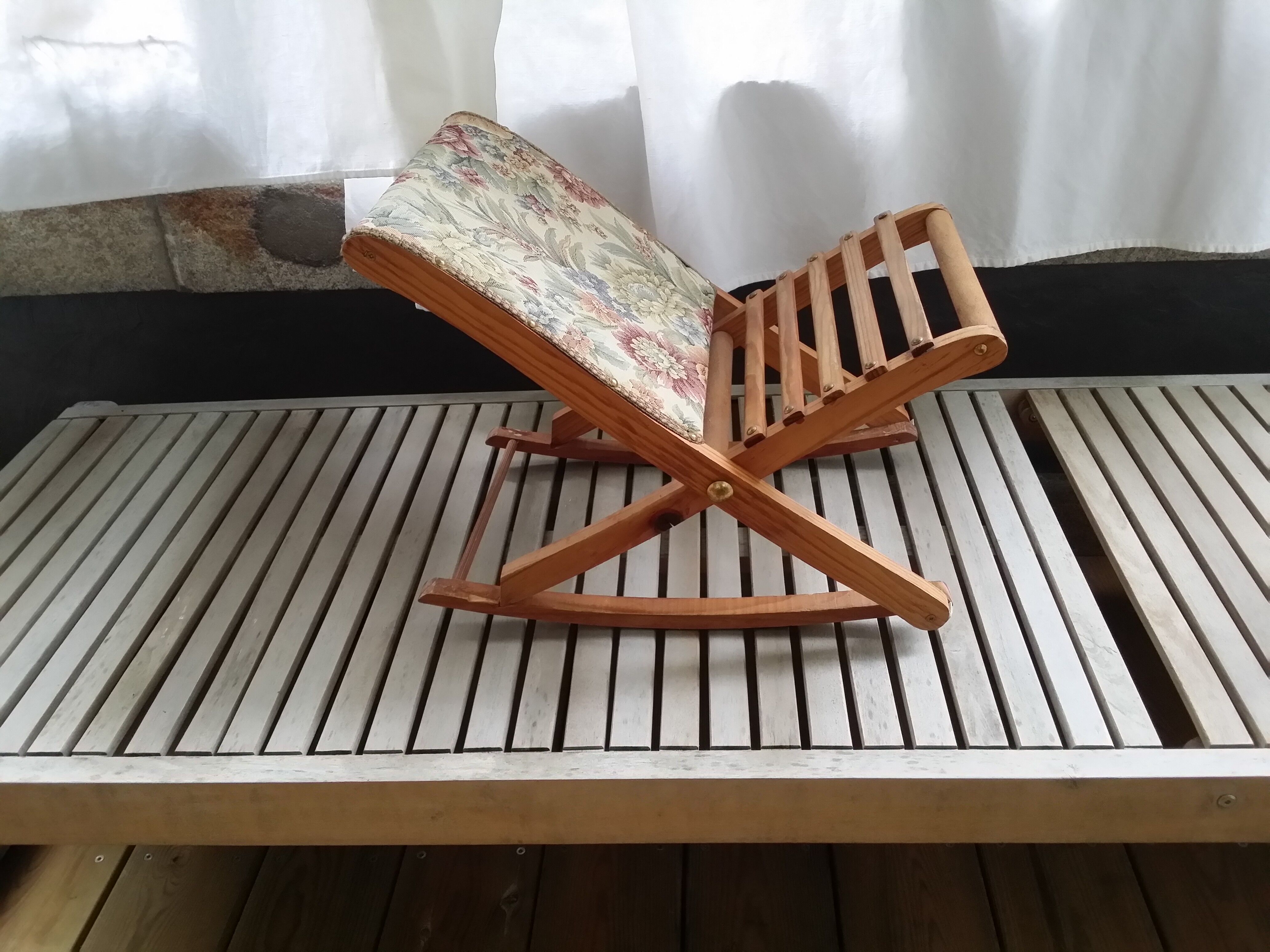 Wooden footrest and vintage tapestry
