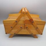 Little worker sewing old wooden table