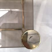 Square side table in metal and smoked glass.
