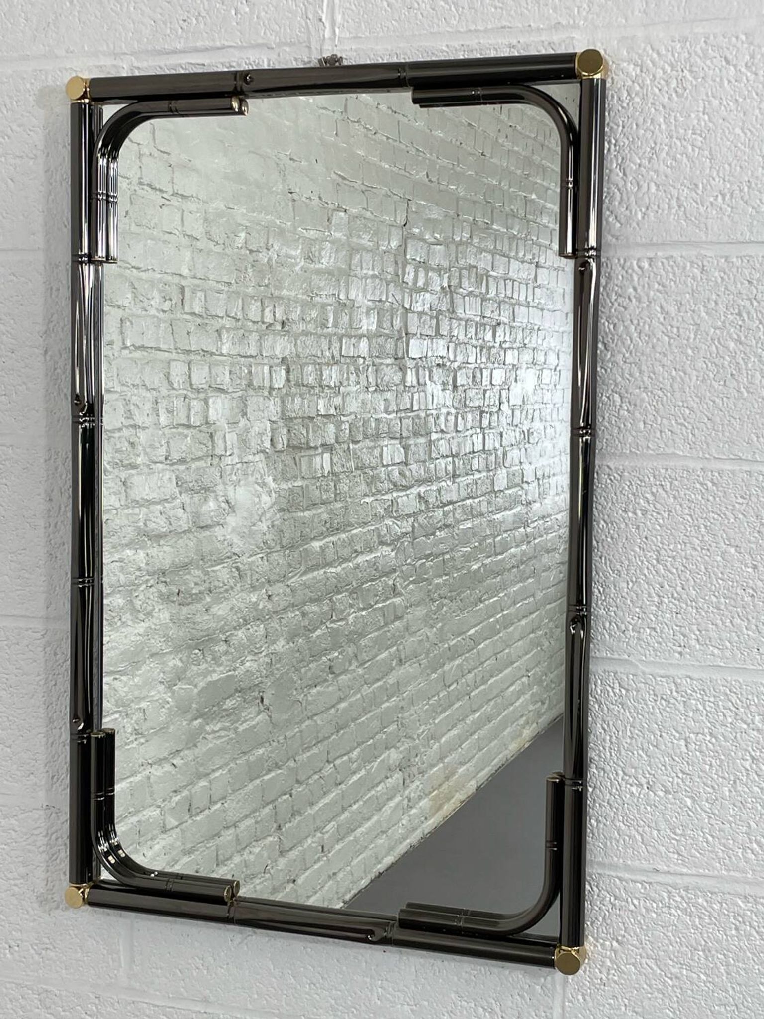 Mirror in black metal and brass with gunmetal finish