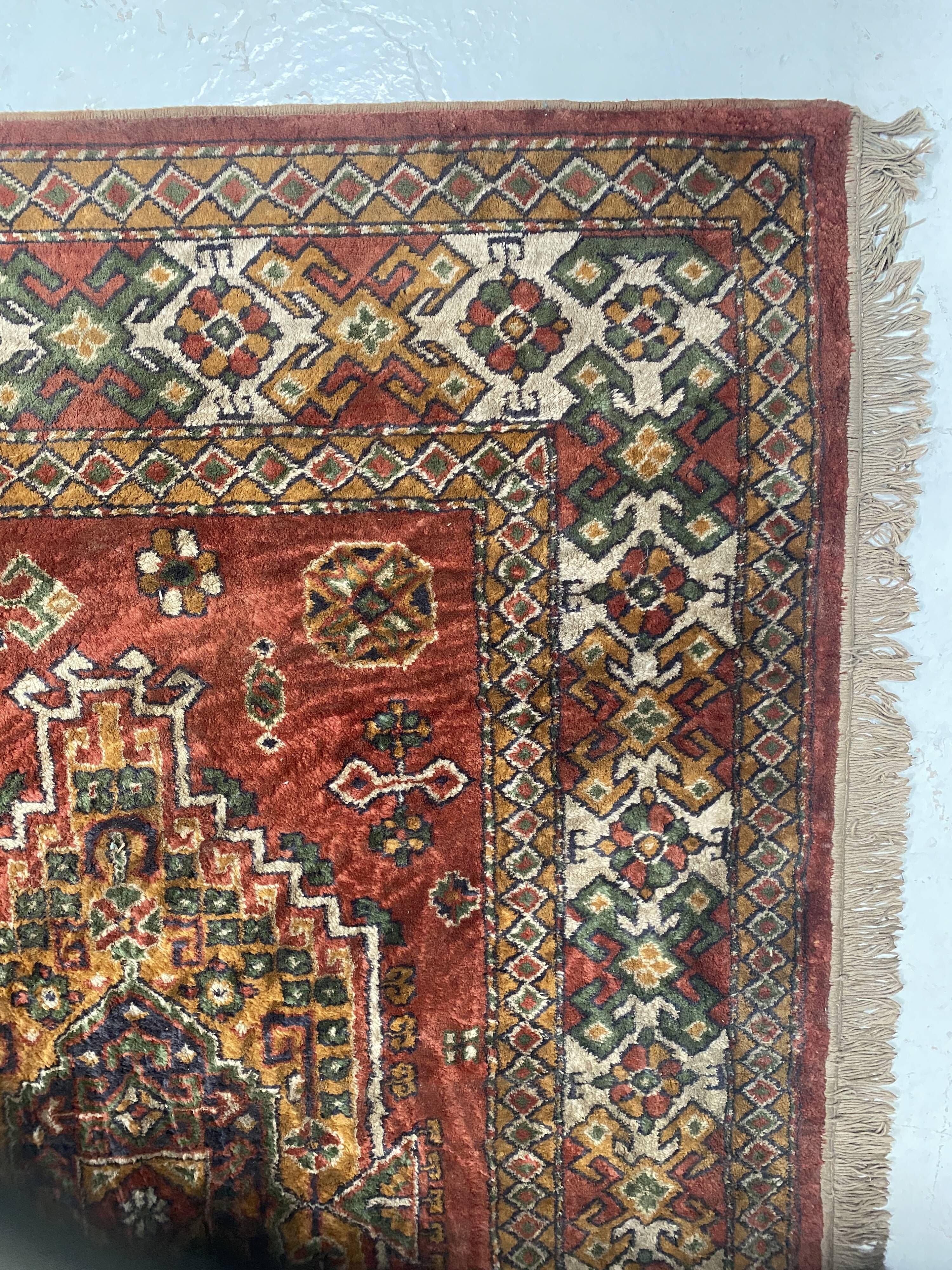 Antique wool rugs with designs on a red background, 20th century.