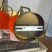 Pair of wall sconces with orange opaline glass globes and brass.