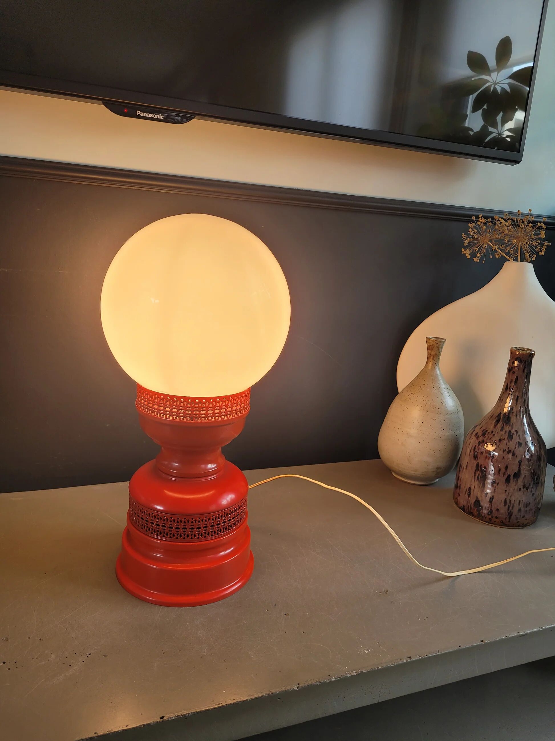 Vintage globe lamp with a metal base, perforated and lacquered in red.