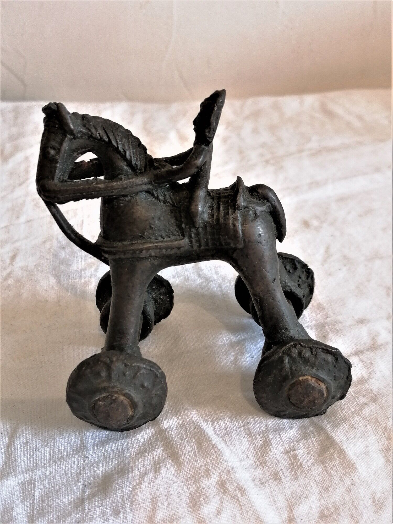 Old child's toy. Horse with bronze wheels. Ethnic object.