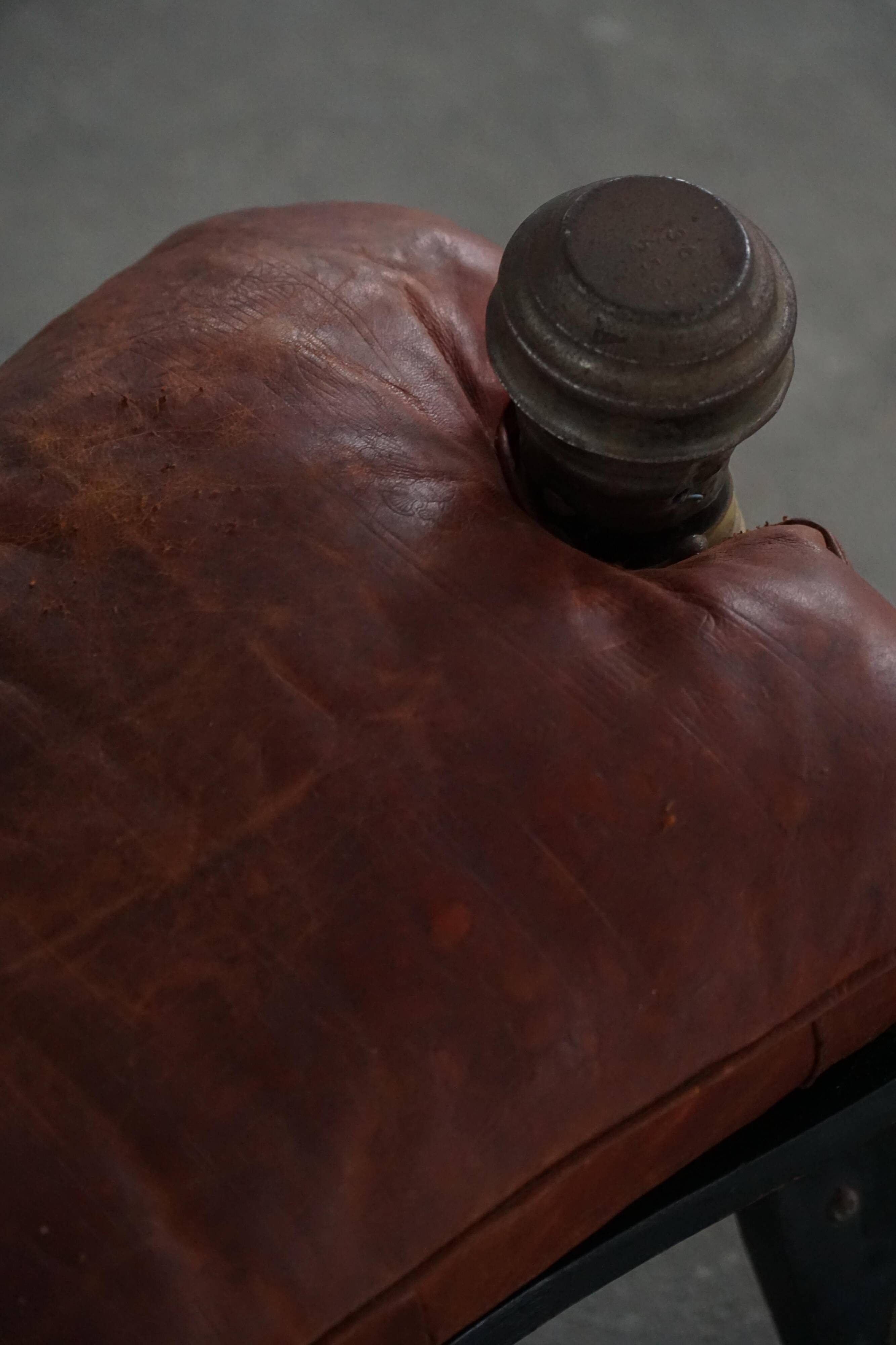 Dark red upholstered camel saddle stool, 20th century, North Africa.