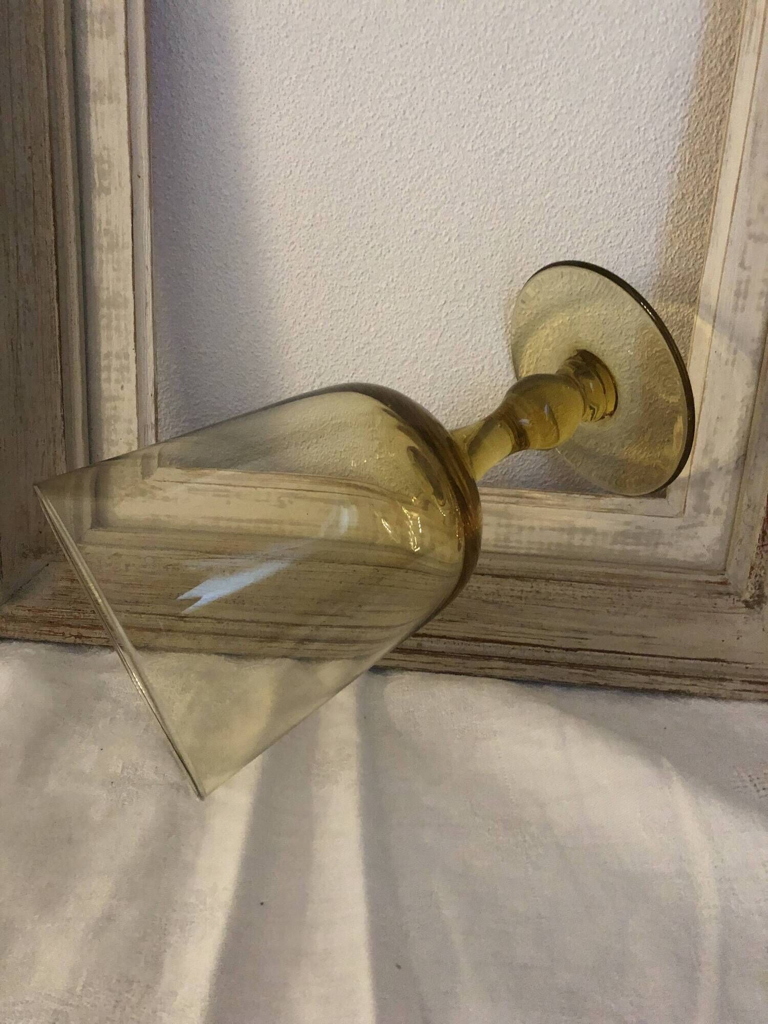 Yellow chalice vase, yellow glass vase on a pedestal.