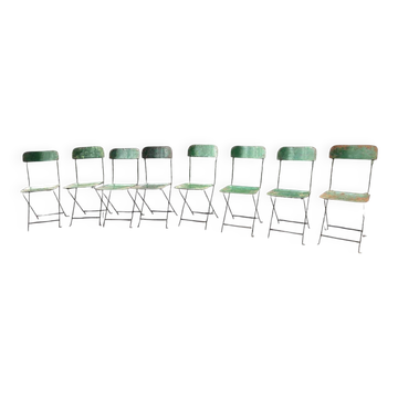 Set of 8 green painted metal industrial folding chairs.
