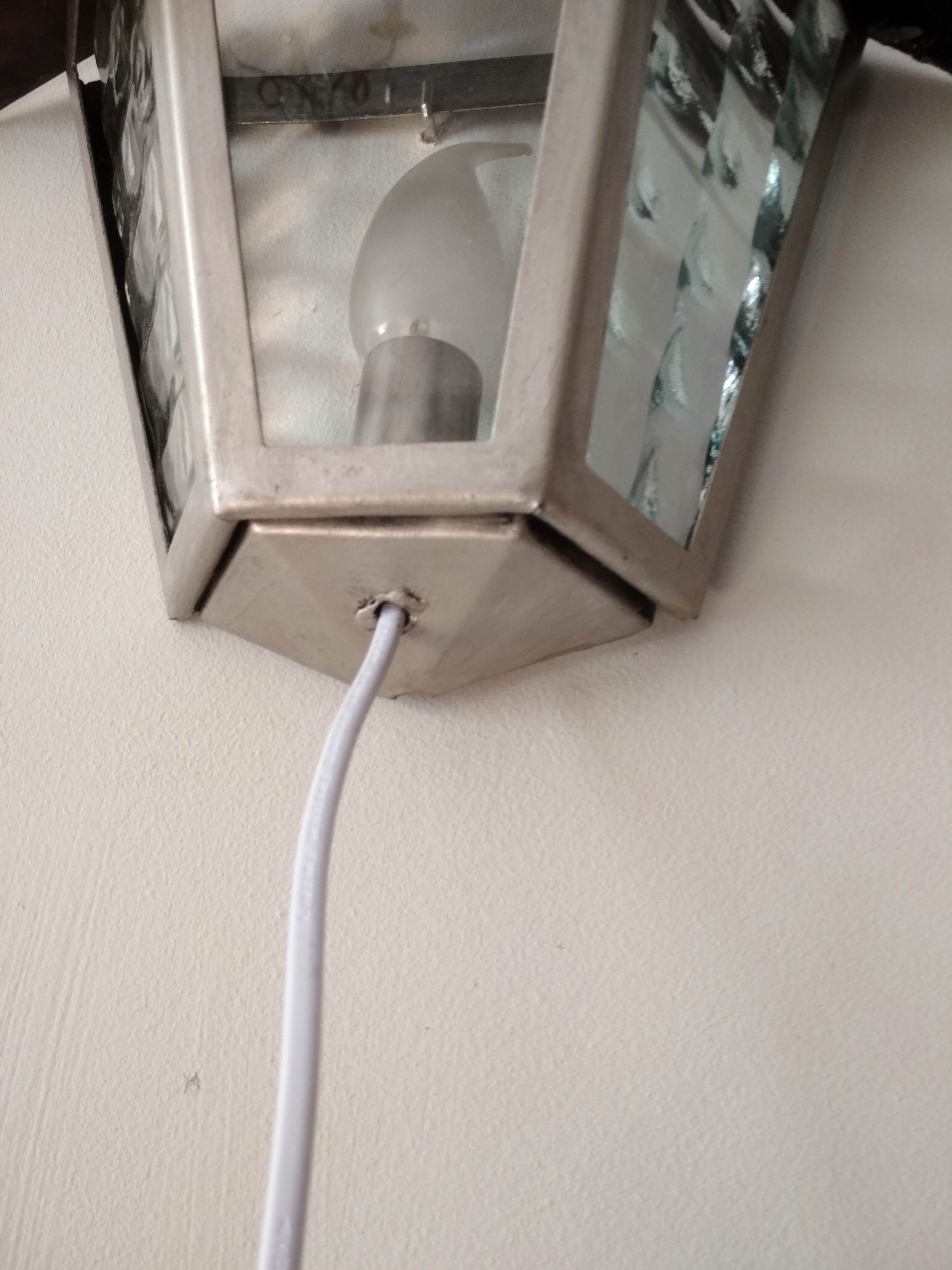 Half grey metal wall sconce and 3 windows